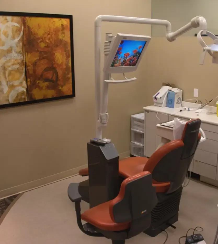 Treatment room with a brown patient chair and wall screen