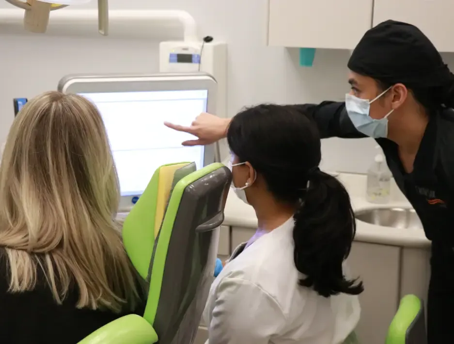 Team member showing a patient a screen in the treatment room