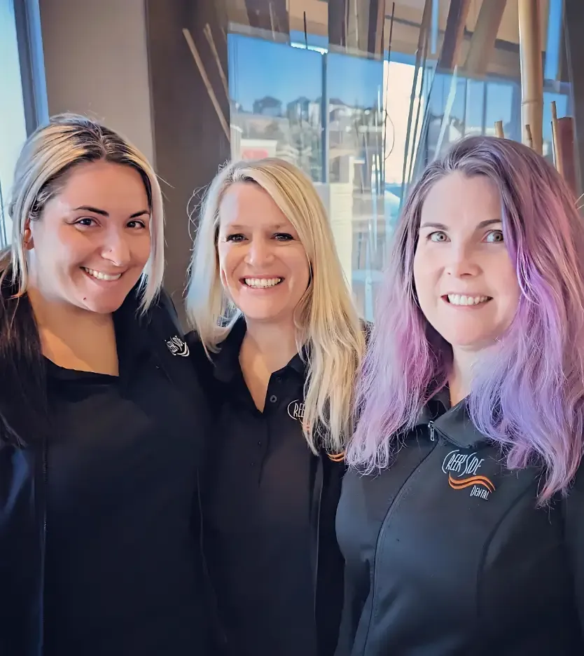 Three team members smiling together